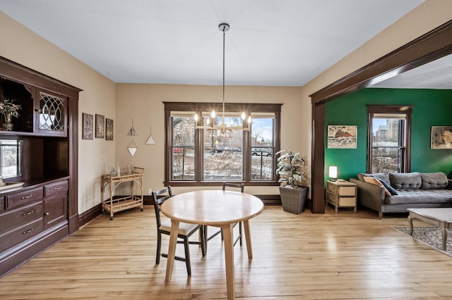 dining space with a notable chandelier and light wood-type flooring