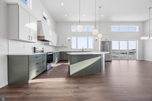 kitchen featuring gray cabinetry, hanging light fixtures, premium range hood, and appliances with stainless steel finishes