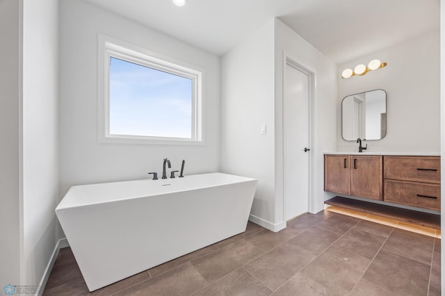 bathroom with tile patterned flooring, vanity, and a bath