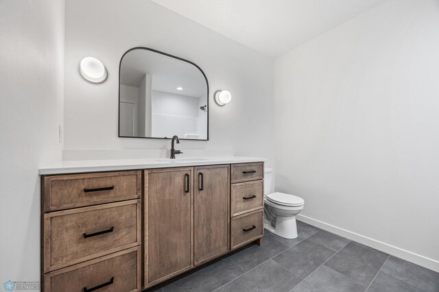 bathroom featuring tile patterned flooring, vanity, and toilet