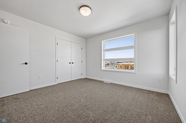 unfurnished bedroom with carpet flooring and a closet