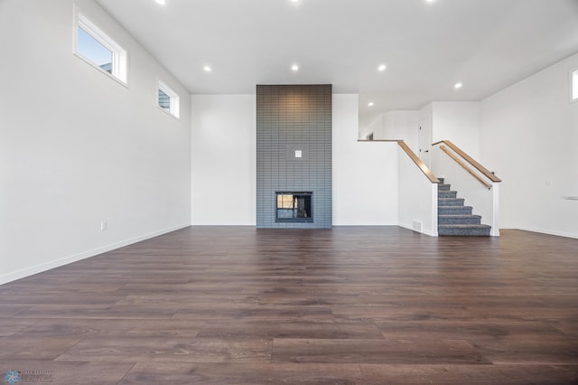 unfurnished living room with dark hardwood / wood-style flooring and a fireplace