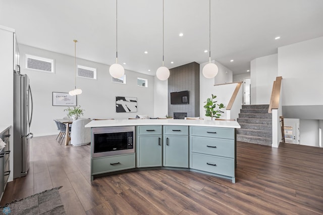 kitchen with dark wood-type flooring, freestanding refrigerator, built in microwave, and open floor plan