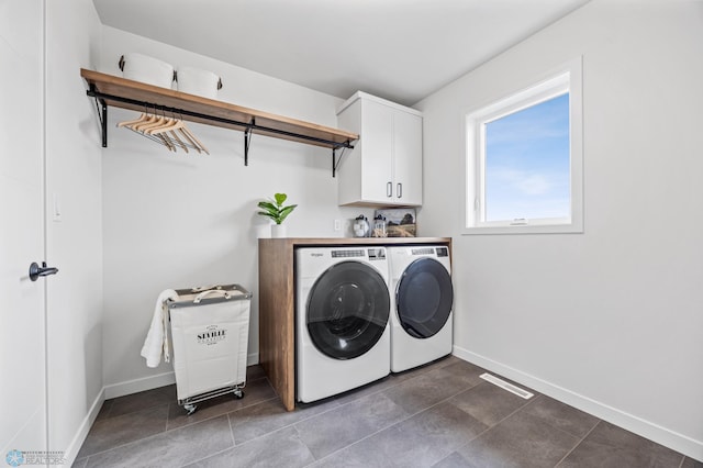 laundry area featuring baseboards, visible vents, cabinet space, and washing machine and clothes dryer