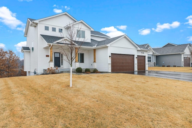 modern farmhouse featuring a garage, roof with shingles, driveway, and a front lawn