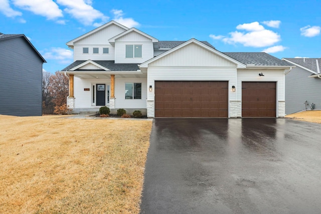 view of front of home featuring a garage, aphalt driveway, a front lawn, and a shingled roof