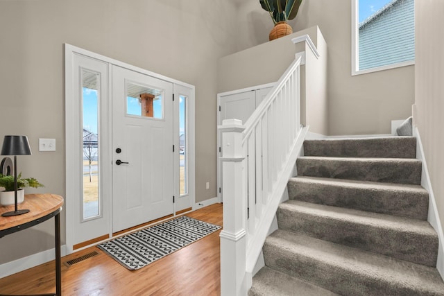 entrance foyer with stairs, baseboards, and wood finished floors