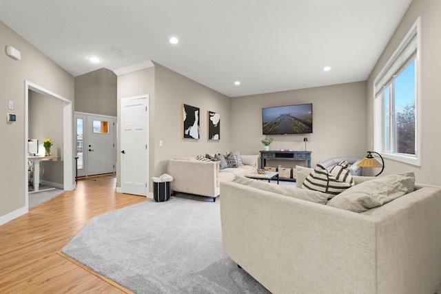 living area featuring baseboards, light wood-style flooring, and recessed lighting