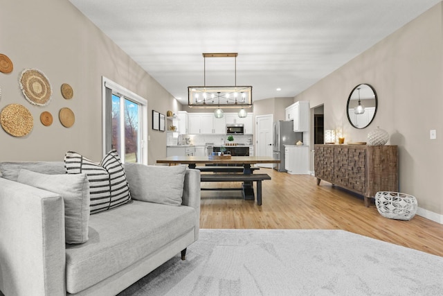 living area with baseboards and light wood finished floors