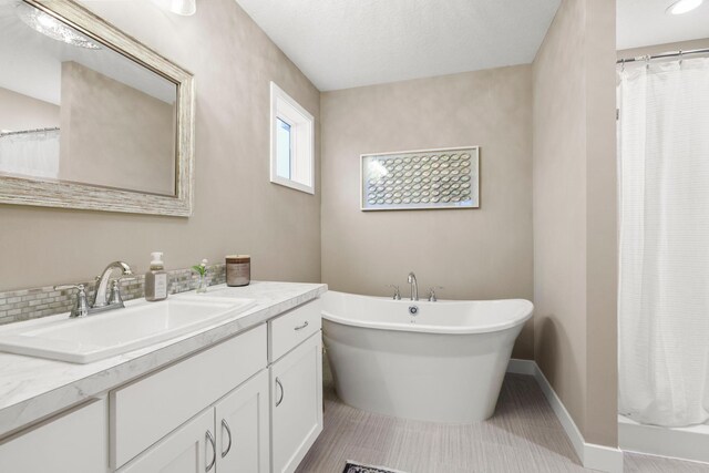 bathroom featuring a shower with curtain, a soaking tub, vanity, and baseboards