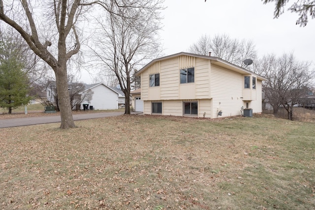 view of side of property with cooling unit and a yard