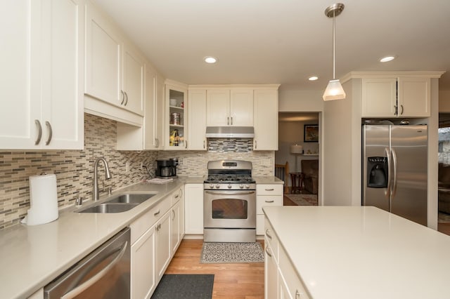 kitchen featuring sink, decorative light fixtures, backsplash, appliances with stainless steel finishes, and white cabinets