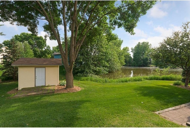 view of yard featuring a water view and a shed