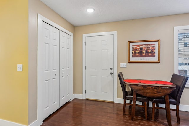 foyer featuring dark wood-type flooring and a textured ceiling