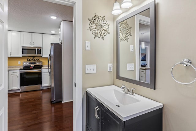 bathroom with vanity, wood-type flooring, and a textured ceiling