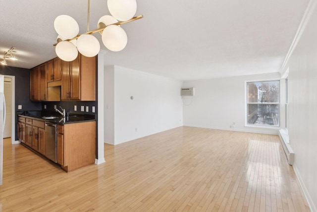 kitchen with dishwasher, an AC wall unit, sink, and light wood-type flooring