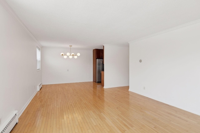 unfurnished room with ornamental molding, an inviting chandelier, baseboard heating, and light hardwood / wood-style flooring