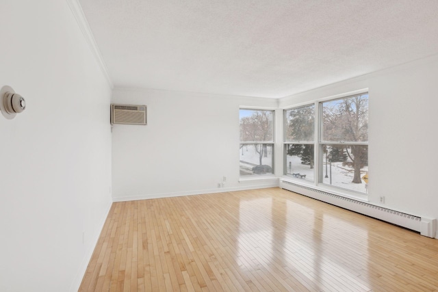 unfurnished room with crown molding, hardwood / wood-style flooring, a wall mounted AC, a textured ceiling, and a baseboard radiator