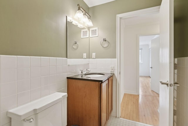 bathroom featuring tile walls, vanity, tile patterned flooring, and toilet