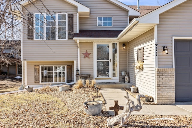 exterior space featuring an attached garage and roof with shingles