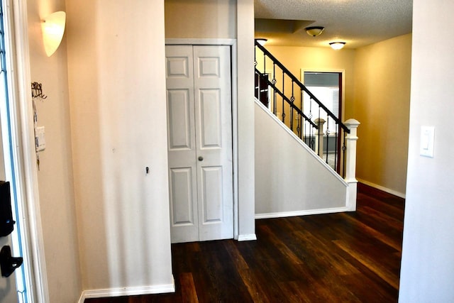 stairway with hardwood / wood-style floors and a textured ceiling