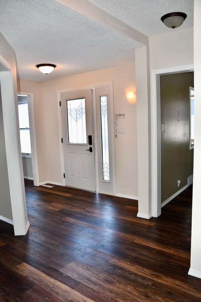 foyer featuring dark wood-type flooring and a textured ceiling