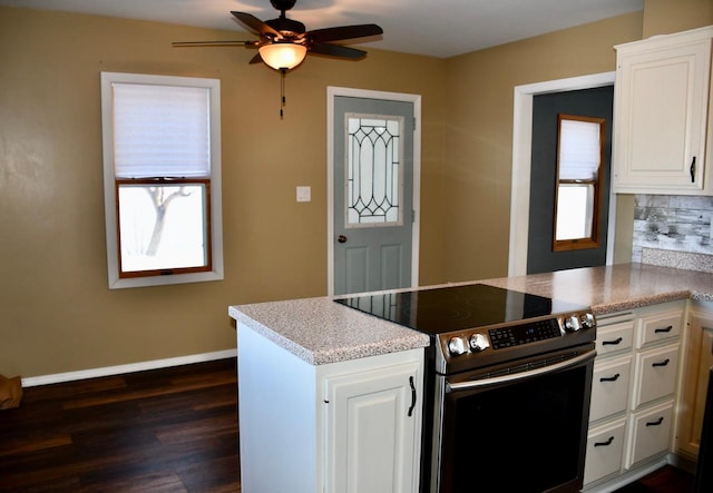 kitchen with white cabinetry, kitchen peninsula, stainless steel range with electric cooktop, and a wealth of natural light