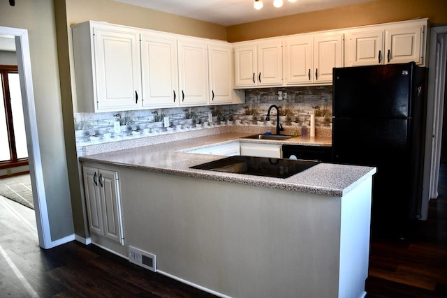 kitchen featuring dark hardwood / wood-style floors, tasteful backsplash, sink, white cabinets, and black appliances