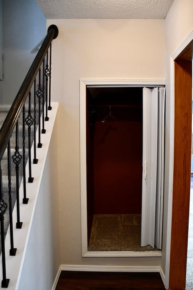 staircase featuring a textured ceiling