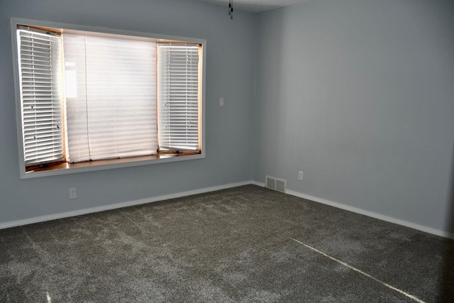 spare room with dark carpet