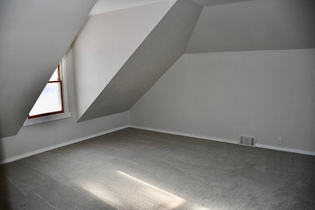 additional living space with lofted ceiling and dark carpet