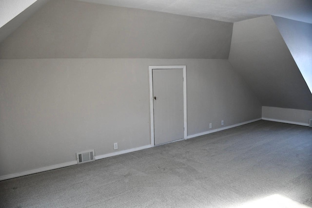 bonus room with lofted ceiling and carpet flooring