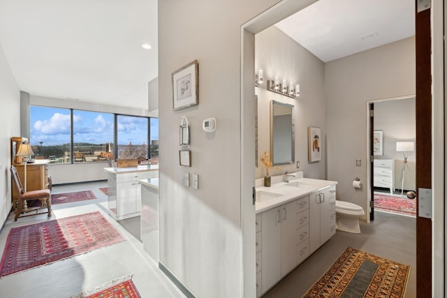 bathroom with vanity, concrete floors, and toilet