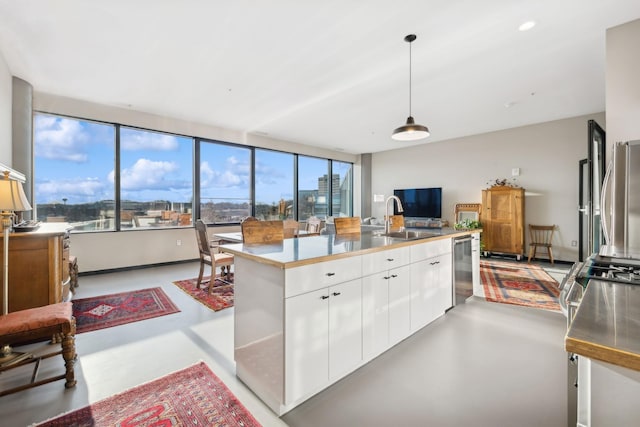 kitchen featuring white cabinetry, a center island, sink, and pendant lighting