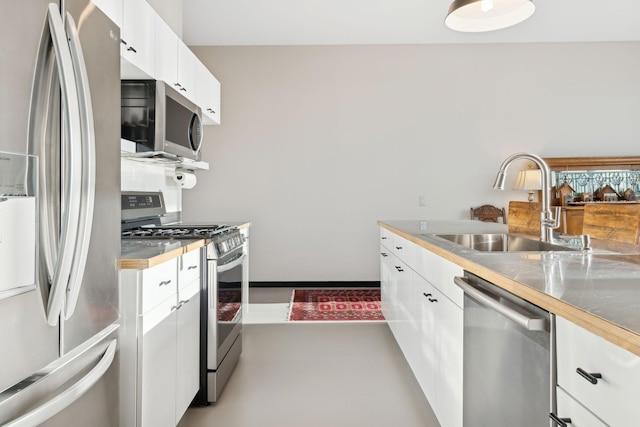 kitchen featuring stainless steel counters, appliances with stainless steel finishes, sink, and white cabinets