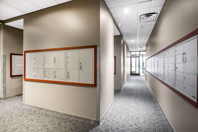 hallway with a paneled ceiling and mail boxes