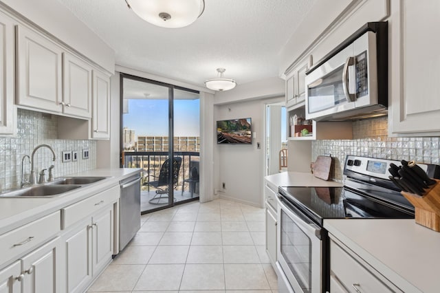 kitchen with appliances with stainless steel finishes, sink, and white cabinets