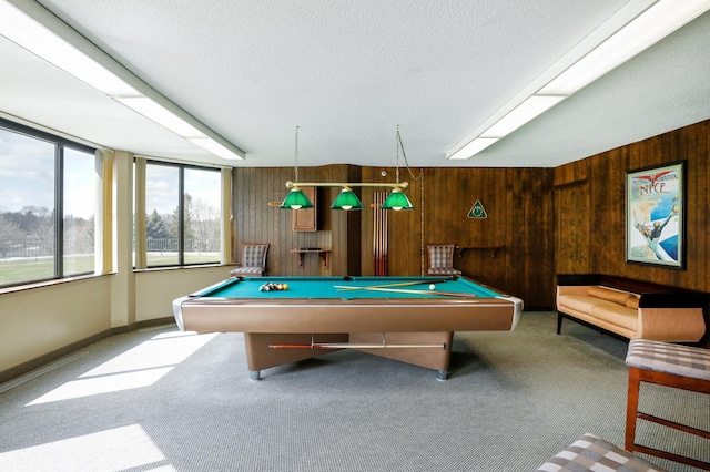 recreation room with carpet flooring, pool table, a textured ceiling, and wood walls