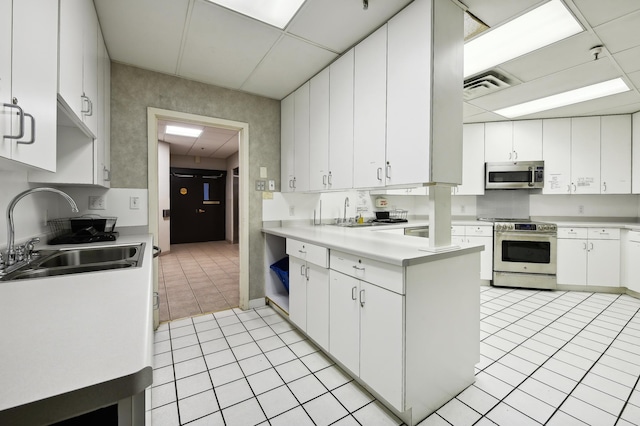 kitchen featuring white cabinetry, sink, light tile patterned floors, and appliances with stainless steel finishes