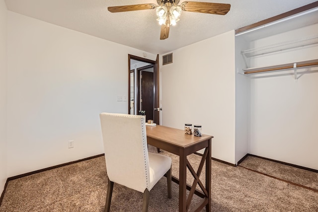 home office featuring ceiling fan, carpet, and a textured ceiling