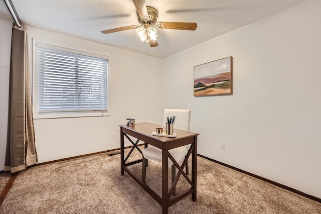 carpeted home office featuring ceiling fan