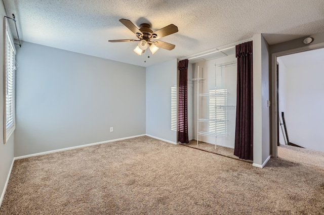 unfurnished bedroom with carpet flooring, a textured ceiling, and ceiling fan