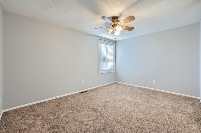 empty room featuring ceiling fan, carpet, and a textured ceiling