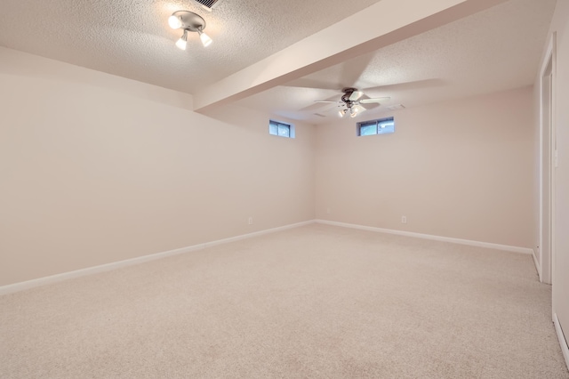 carpeted spare room featuring ceiling fan, a textured ceiling, and beam ceiling