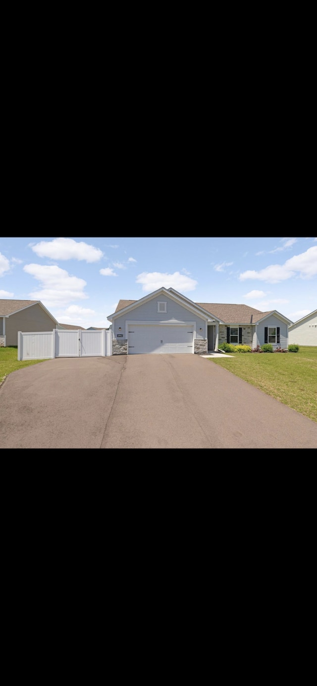 ranch-style home with a garage and a front yard