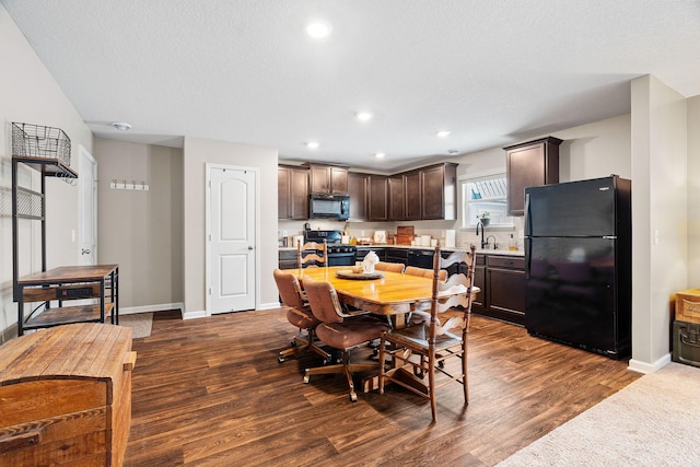 dining area featuring dark hardwood / wood-style floors, sink, and a textured ceiling