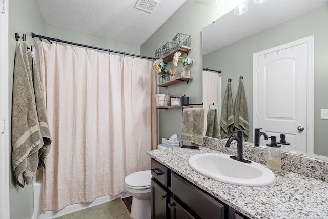 bathroom featuring vanity, toilet, and a textured ceiling