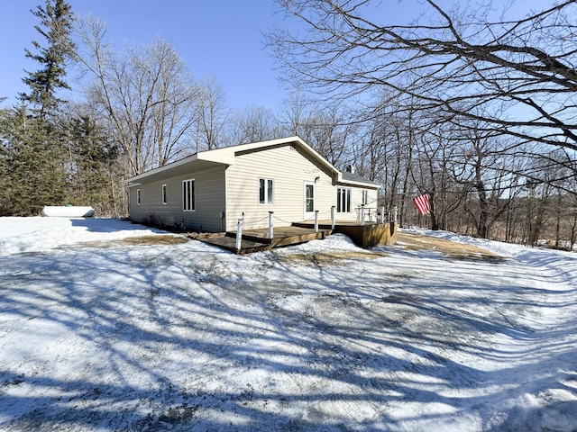 snow covered property featuring a wooden deck