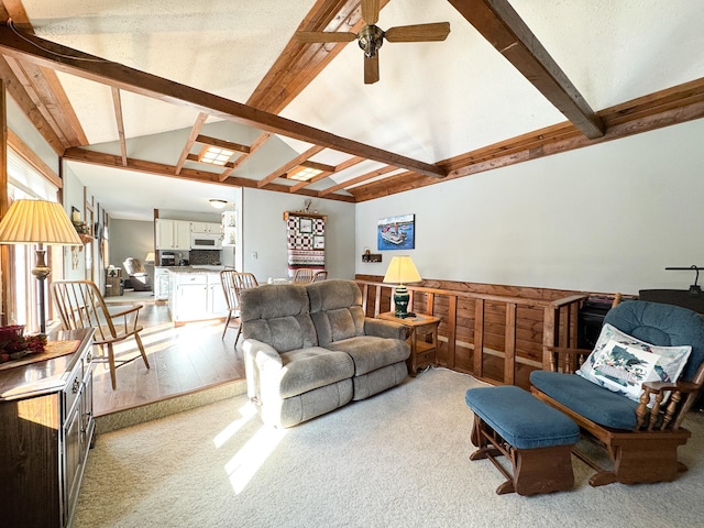 living area with light wood-style flooring, beam ceiling, high vaulted ceiling, and ceiling fan