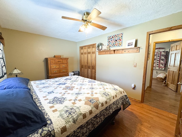 bedroom with a ceiling fan, light wood-style floors, a closet, and a textured ceiling